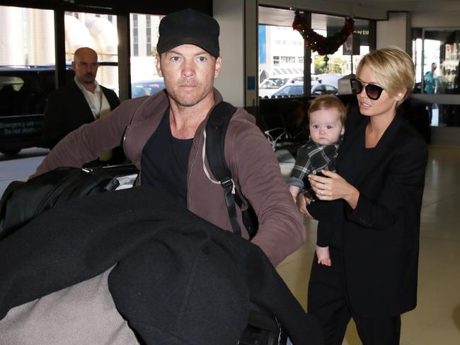 Lara Bingle, Sam Worthington and son Rocket arriving at Sydney airport.