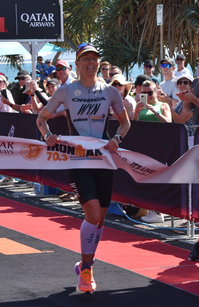 Women's first place: Rebecca Clarke crossing the finish line at the Sunshine Coast Ironman 70.3 2023.