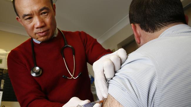 Former NSWAMA president, Dr Kean-Seng Lim administering a flu vaccination to Exercise Physiologist Daniel Parker at his practice in Mt Druitt. Picture: John Appleyard