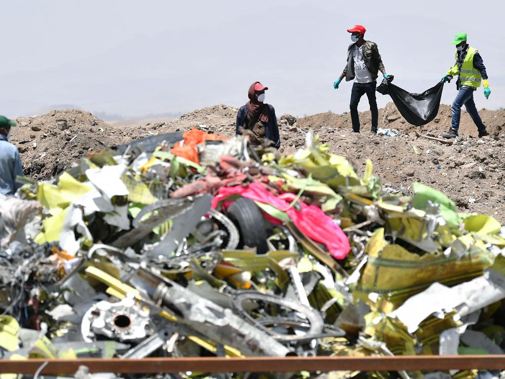 A crew working with an investigative team to clear the site after the Sunday crash of the Ethiopian Airlines operated Boeing 737 MAX aircraft. Picture: AFP