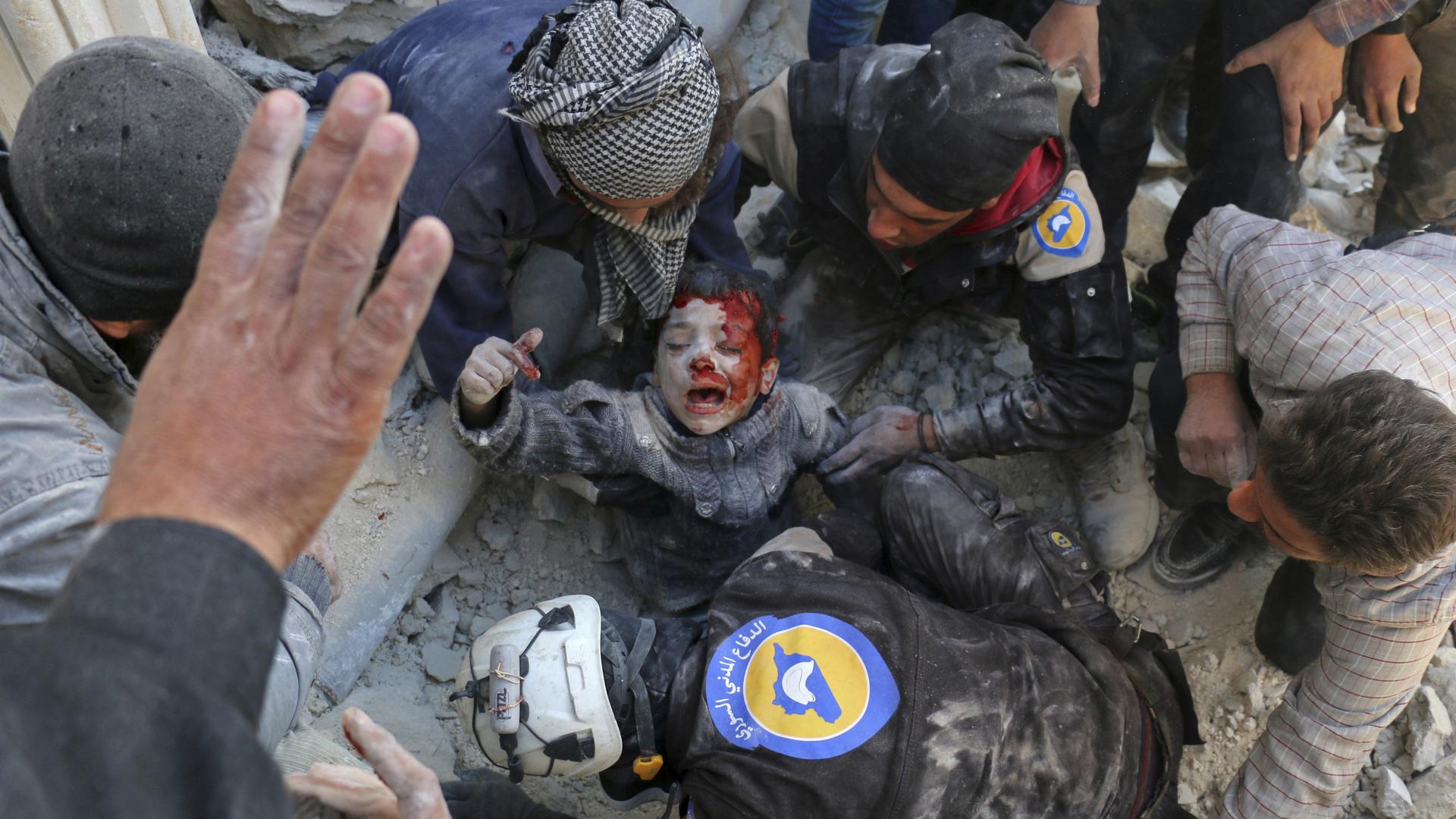 In this image released Monday Feb. 13, 2017, by World Press Photo titled "Rescued From The Rubble" by photographer Ameer Alhalbi, Agency France-Presse, which won second prize in the Spot News, Stories, category of the World Press Photo contest shows Syrian civil defense volunteers, known as the White Helmets, rescueing a boy from the rubble following a reported barrel bomb attack on the Bab al-Nairab neighborhood of Aleppo on Nov. 24, 2016. (Ameer Alhalbi, Agence France-Presse, World Press Photo via AP)