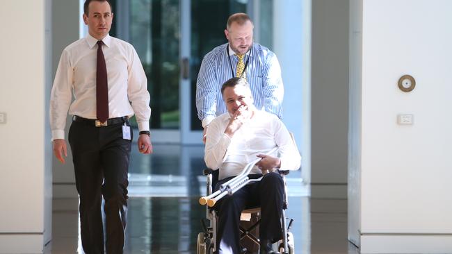 Jamie Briggs in a wheelchair arriving party room meeting at Parliament House in Canberra. Pic by kym Smith