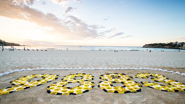 The number 9,883 was written on the sand at Bondi beach to symbolise Australians who will die from melanoma in the next five years.