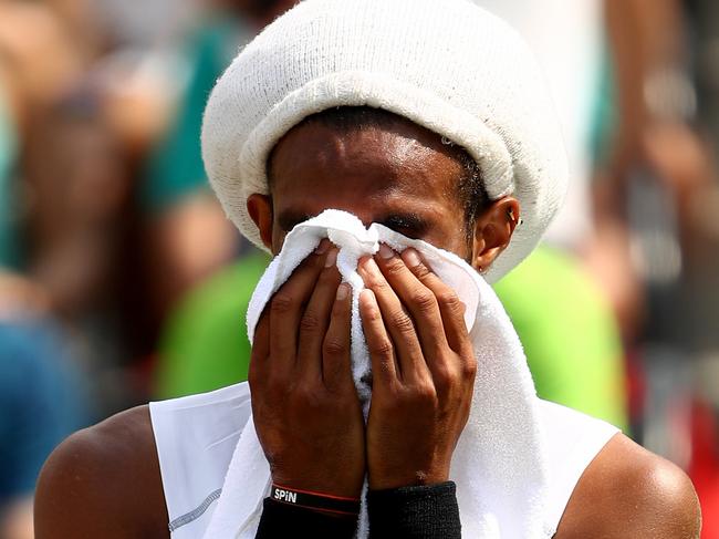 Dustin Brown of Germany receives treatment after injuring his ankle before retiring from the match during his match against Thomaz Bellucci