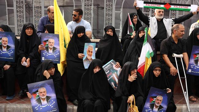 Iranians hold Palestinian flags and portraits of late Hamas leader Ismail Haniyeh during his funeral procession in Tehran.