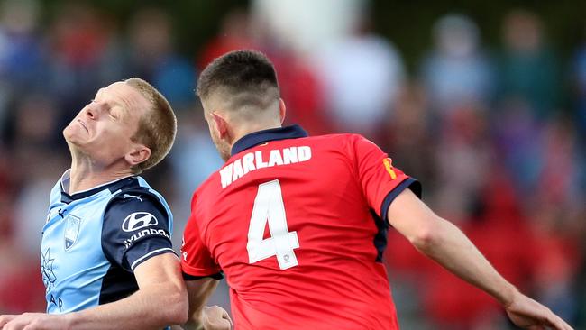 Matthew Simon of Sydney FC clashes with Ben Warland of Adelaide United