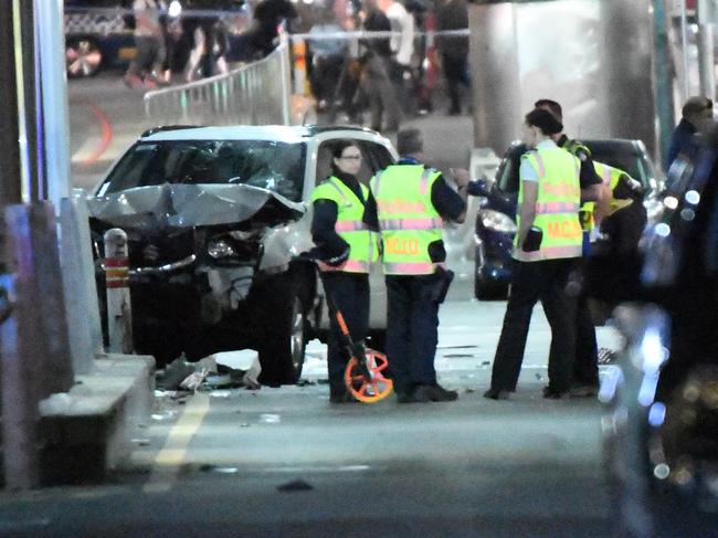 A damaged vehicle is seen at the scene of an incident involving a vehicle on Flinders Street, in Melbourne, Thursday, December 21, 2017. Earlier a speeding car ploughed through pedestrians at Flinders Street in Melbourne's CBD in what police believe was a deliberate act. . (AAP Image/James Ross) NO ARCHIVING