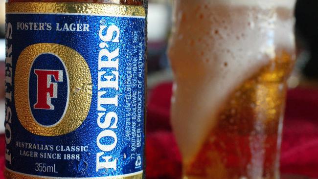 p44// A bottle of Foster's beer near a freshly poured glass of beer on a bar of a hotel in Sydney, Feb 10, 2004. REUTERS PicWill/Burgess Fosters label