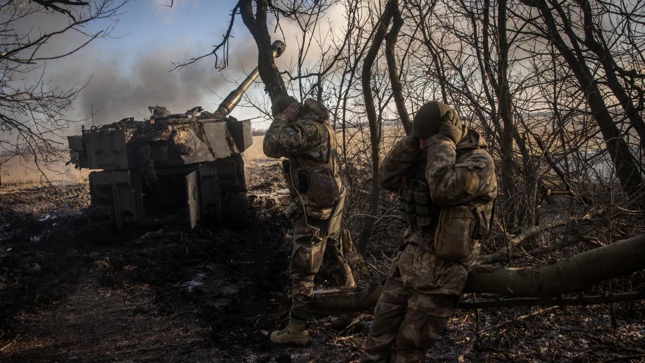 Members of a Ukrainian artillery unit cover their ears as an M109 self propelled artillery unit is fired at Russian mortar positions in Donetsk Region. Picture: Chris McGrath/Getty Images.