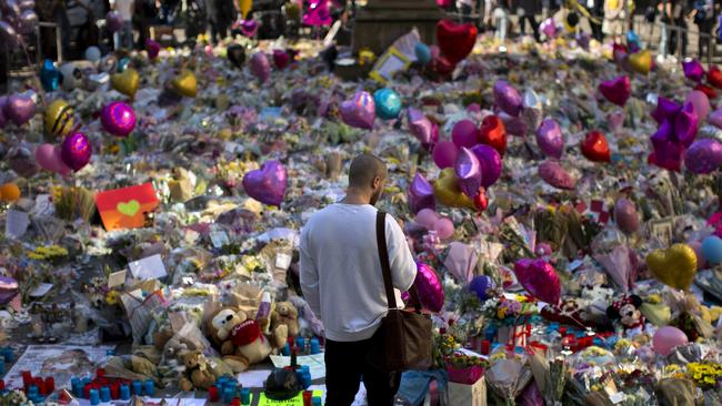 A man stands next to flowers for the victims of Monday's terror attack in Manchester. Picture; AP.