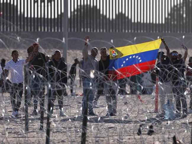 Migrants holding a Venezuelan flag after crossing from Mexico. Picture: Herika Martinez/AFP