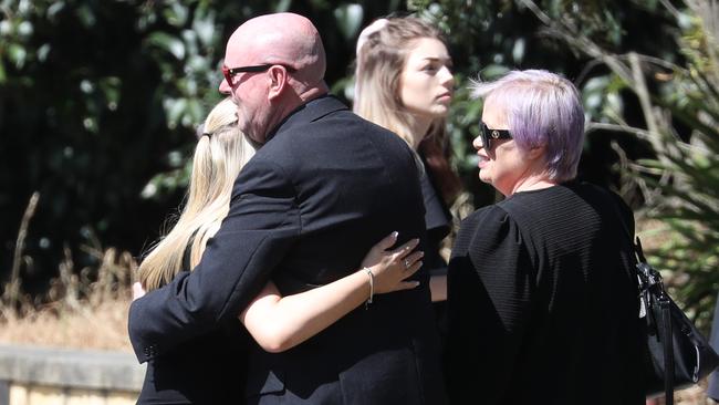 Loved ones embrace each other before the service. Picture: John Grainger