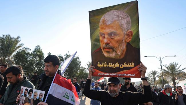 A man carries a poster of slain Palestinian Hamas leader Yahya Sinwar, during a rally in the Shula area west of Baghdad on January 1. Picture: AFP