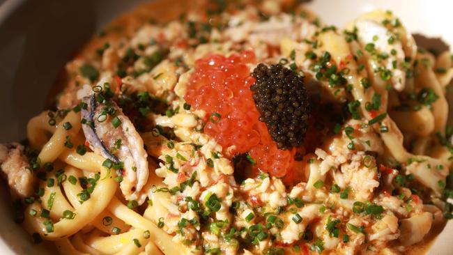 Golden strands of egg taglierni are tossed with hand-picked blue swimmer crab, salmon roe pearls, fermented chilli and crustacean butter in this decadent pasta dish. Picture Kelly Barnes