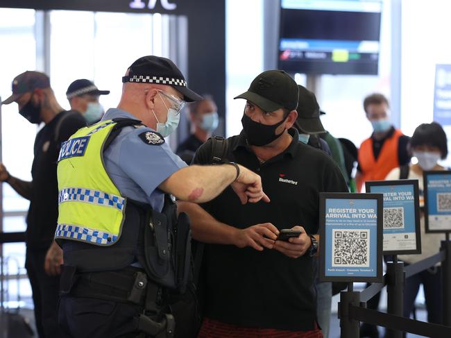 PERTH, AUSTRALIA - FEBRUARY 05: Arriving passengers scan the arrival registration QR codes at the Qantas Domestic terminal on February 05, 2022 in Perth, Australia. Western Australia is set to welcome some 10,000 arrivals over the weekend, local media reports said, as it eases its "hard border", which was among the strictest measures taken by any state, territory, or country in keeping potential Covid-19 infections at bay.  (Photo by Paul Kane/Getty Images)