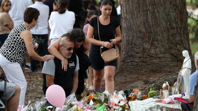 United in grief … hundreds mourn at the site where the children died. Picture: Jonathan Ng