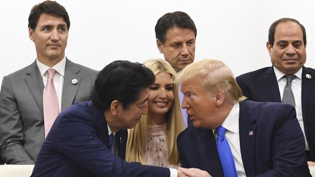 Shinzo Abe shakes hands with Donald Trump as daughter Ivanka watches on, in 2019. Picture: AAP Image/Lukas Coch