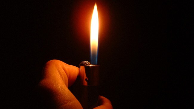 A man holding a cigarette lighter. Generic image.