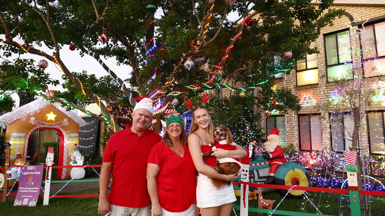 Darren and Trish Augustus with their daughter Amber and dog Apollo outside their North Ryde home decorated with Christmas Lights. Picture: Jonathan Ng