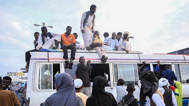 \People struggling to commute gather around a packed bus in Port Sudan as transportation is strangled after authorities reportedly changed two currency notes, invalidating old notes, on December 30, in the Red Sea port city. Picture: AFP