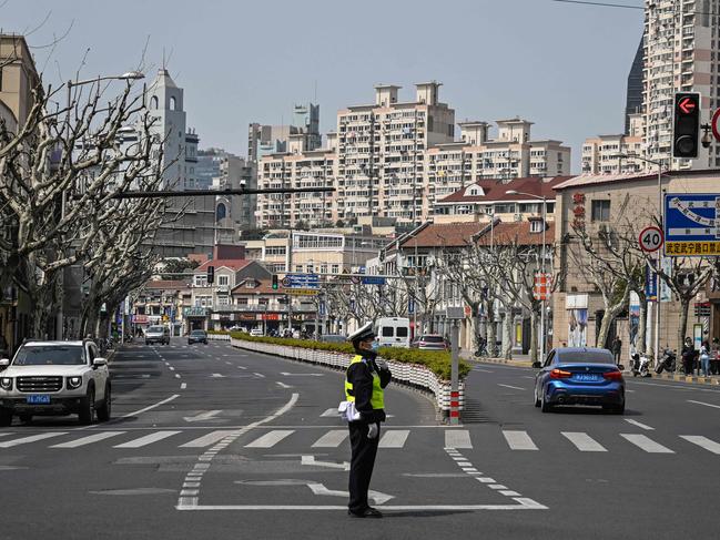 A policeman directs traffic on a near-empty street in Jingan district, in Shanghai. The city is under a strict lockdown. Picture: AFP