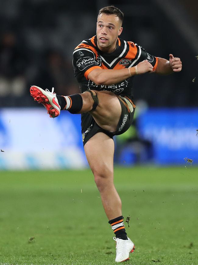 Tigers half Luke Brooks kicks the winning field. Picture: Brett Costello