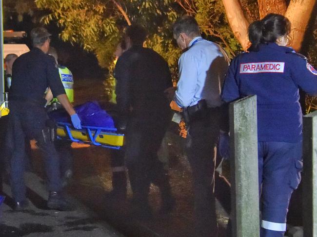 Emergency services workers remove one of the bodies from the lake. Picture: Tony Gough