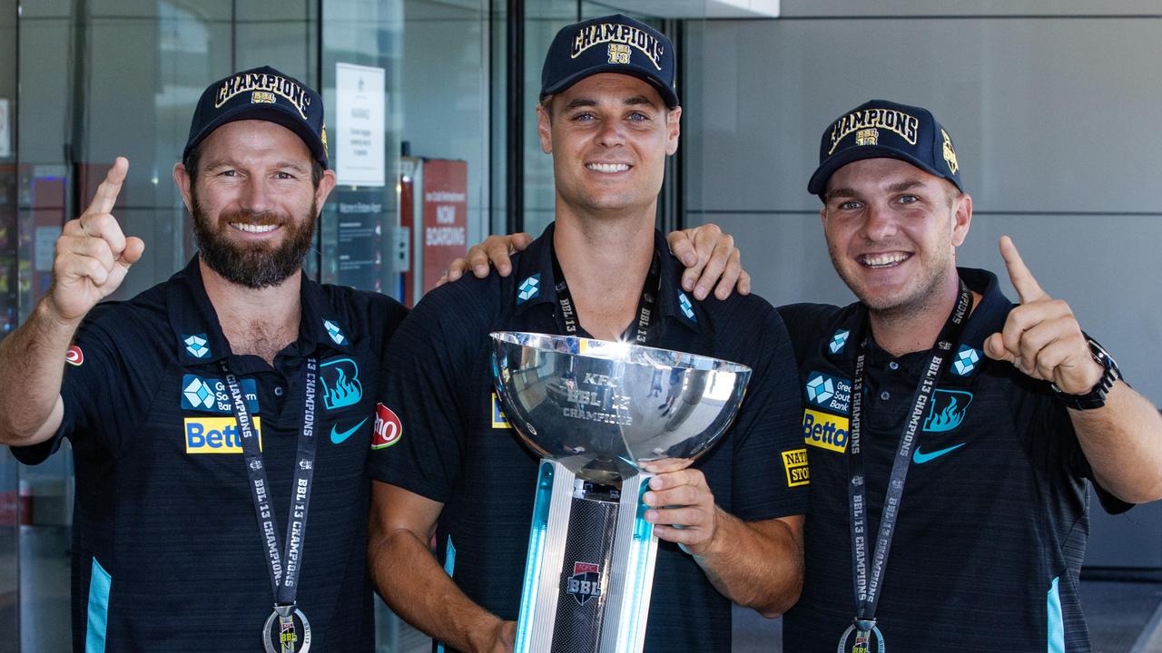 Brisbane Heat’s Michael Neser, Spencer Johnson and Josh Brown with the BBL trophy at Brisbane Airport. Picture: Nigel Hallett