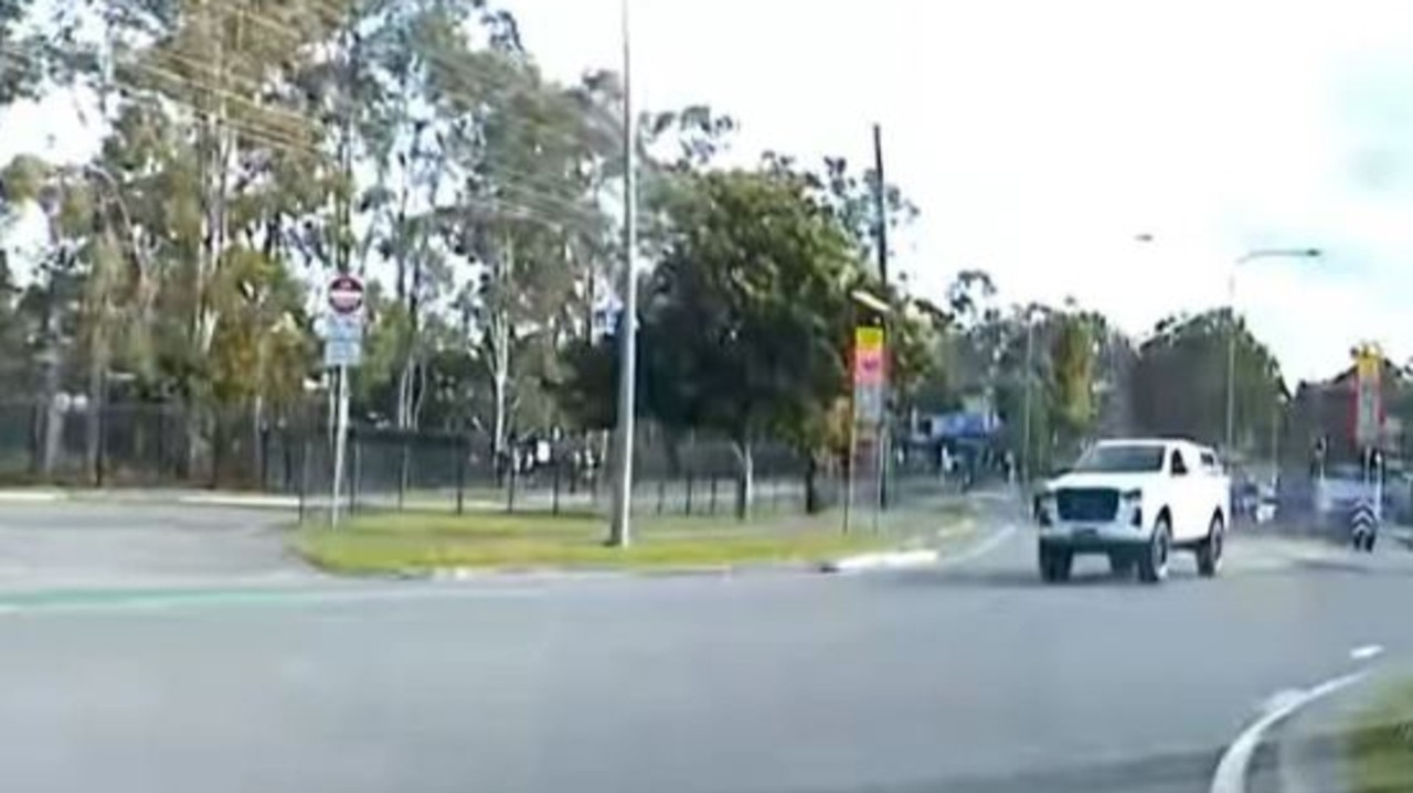 A ute pictured driving on the wrong side of the road outside Helensvale State High School. Picture: Monterey Keys Community Group / Facebook.