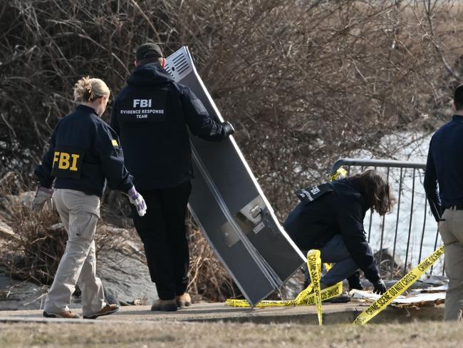 Investigators gather pieces of wreckage along the Potomac River after American Airlines flight 5342 on approach to Reagan National Airport crashed into the river after colliding with a US Army helicopter, near Washington, DC, on January 30, 2025. There are likely no survivors from a collision between a passenger jet and US Army helicopter in Washington, officials said Thursday, as recovery operations pulled 28 bodies from the river into which both crashed. (Photo by ANDREW CABALLERO-REYNOLDS / AFP)