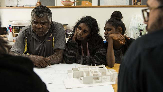 Tennant Creek resident Norm Frank Jupururrla, his wife Serena Morton Nabanunga and daughter look at a cardboard model of a preliminary house designed for the Wilya Junta (Standing Strong) Housing Collaboration. Picture: Supplied/Andrew Quilty.