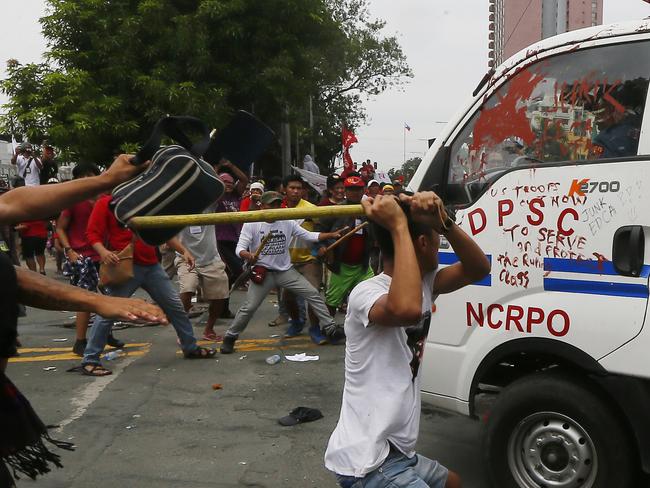 Protesters hit a Philippine National Police van after it rammed into protesters outside the US Embassy in Manila. Picture: Bullit Marquez.