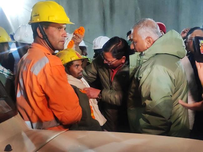 A contruction worker (front 2L) with Chief minister of Uttarakhand Pushkar Singh Dhami (C) following his rescue from inside the under construction Silkyara tunnel. Picture: Department of Information and Public Relation (DIPR) Uttarakhand / AFP