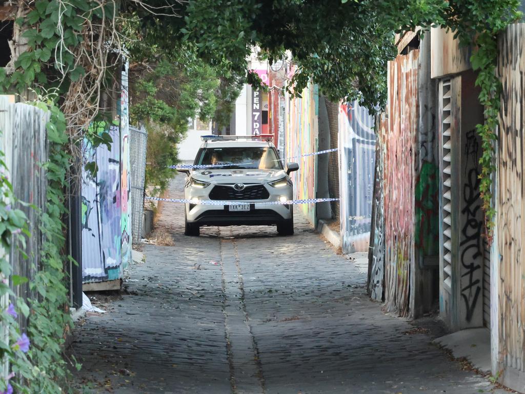 Detectives in the lane behind the property. Picture: David Crosling