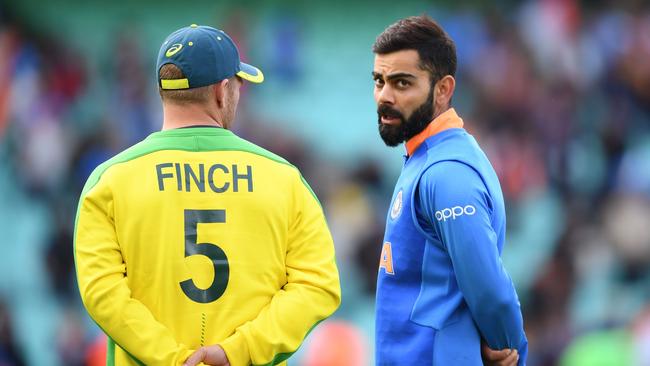 India's captain Virat Kohli gives Aaron Finch a talking-to (Photo by Adrian DENNIS / AFP)