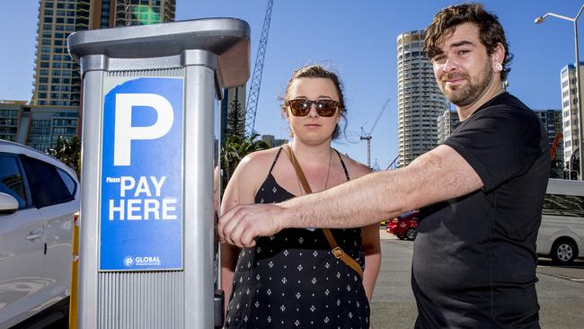 Scott Davey and Malodi McIver from Labrador pay for parking at the Cypress paid parking area in Surfers Paradise. Picture: Jerad Williams