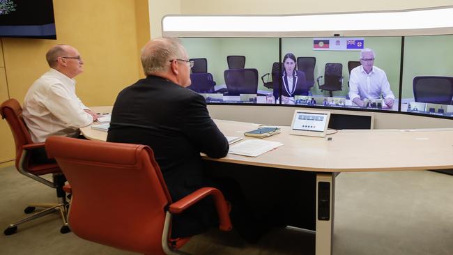 Secretary of the Department of Prime Minister and Cabinet, Phil Gaetjens, and Australian Prime Minister Scott Morrison speak with NSW Premier Gladys Berejiklian (on screen) during a national cabinet meeting. Picture: Getty Images