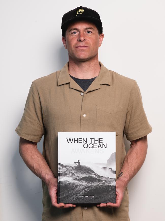 Surfer Marti Paradisis with his new book, When the Ocean Awakens. Picture: Warren Frey