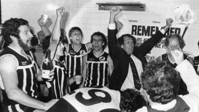 Port Adelaide players (l-r) Tim Evans, Paul Belton, Tony Giles, Mark Williams, coach John Cahill, Milan Faletic, Ian Bradmore and Mark Dawson celebrate with champagne. Robert Dolan is the player bending down.