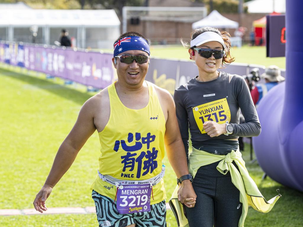 A 10km entrant holds hands with a half marathon runner as they cross the finish line together at the Toowoomba Marathon event, Sunday, May 5, 2024. Picture: Kevin Farmer