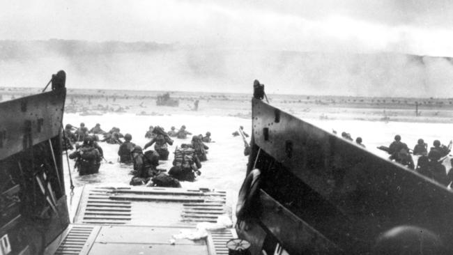 The reality: US infantrymen wade ashore under horrific fire at Omaha Beach, Normandy.