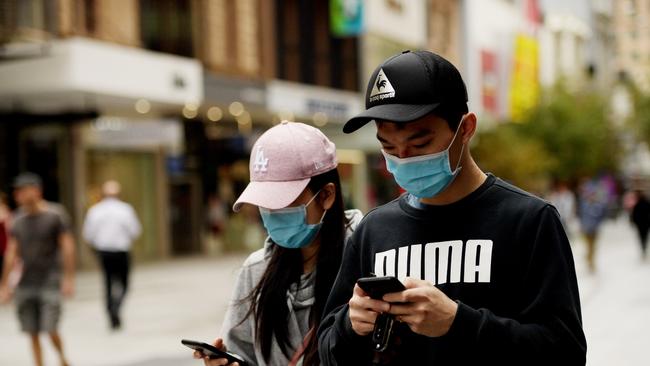 Two people wear surgical masks in Adelaide. Picture: Tracey Nearmy/Getty Images)