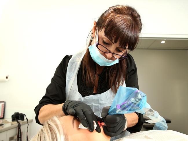 Owner Rita Porreca lip tattoos a patient.                         Picture: Justin Sanson