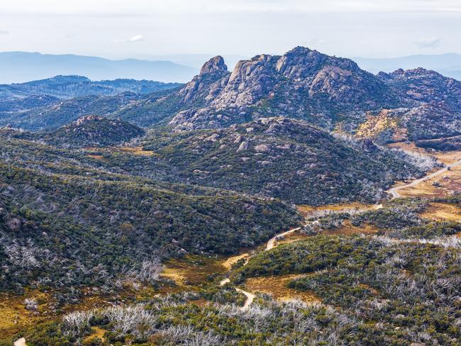 Winding dirt road and rugged cliffs at Mount Buffalo National Park, Victoria, Australia. Credit: Istock