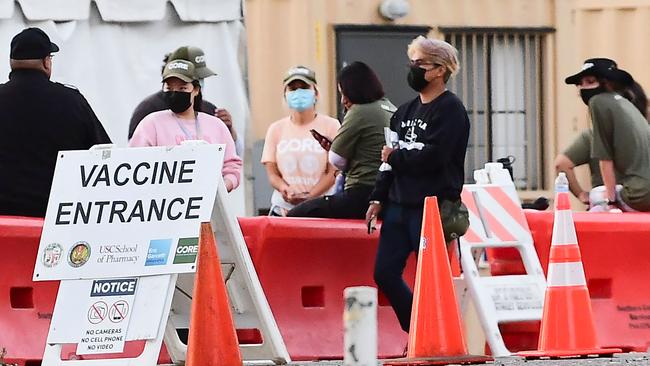 People wearing facemasks outdoors are seen at a Covid-19 vaccine site in LA. Picture: AFP