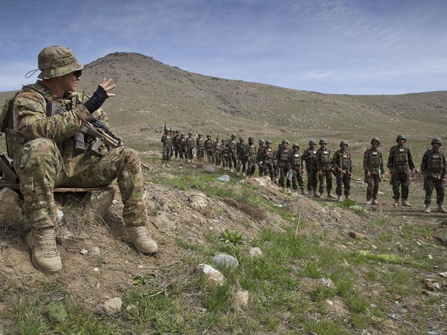 Australian Army soldier Private Jason Knox, a ‘Guardian Angel’, waving to Afghan National Army Officer Academy cadets undergoing training at Camp Qargha during his deployment to Operation Highroad as part of the NATO-led Resolute Support mission in Afghanistan.