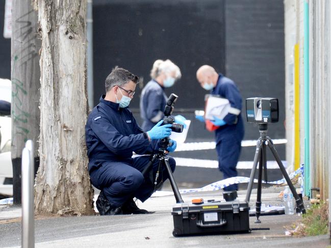 Police examine the scene on Langford St after the fatal shooting. Picture: Andrew Henshaw