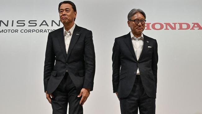 Makoto Uchida (L), president and CEO of Japanese automaker Nissan, and Toshihiro Mibe (R), director, president and representative executive officer of automaker Honda. (Photo by Richard A. Brooks / AFP)