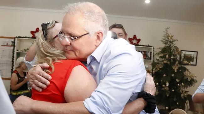 Prime Minister Scott Morrison hugs Helen Glanville while visiting the relief centre in Lobethal, South Australia. Picture: AAP Image/Kelly Barnes