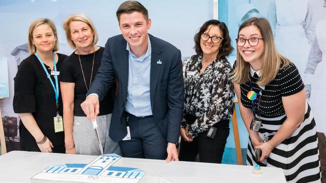 Acting general manager Kiel Harvey cuts a cake to celebrate the hospital's 90th birthday.